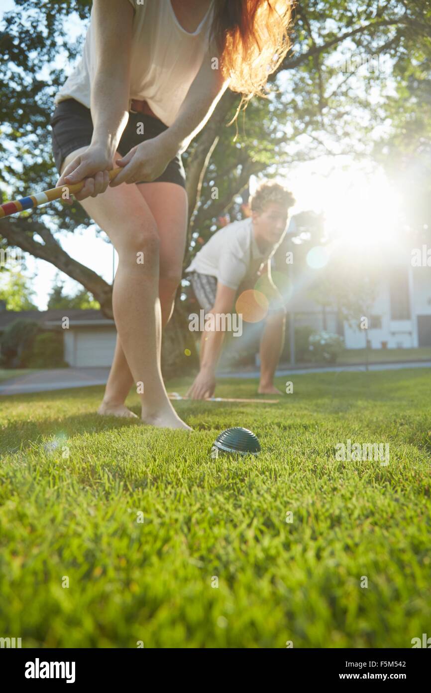 Basso angolo vista della coppia giovane giocando croquet sull'erba Foto Stock