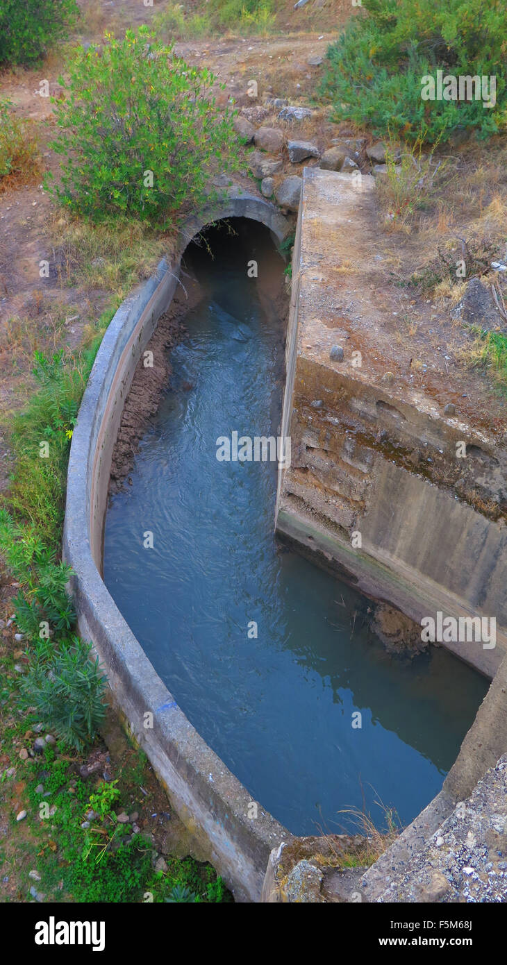 Calcestruzzo canale di irrigazione avvolgimento sotto il ponte stradale vicino a Alora, Andalusia Foto Stock