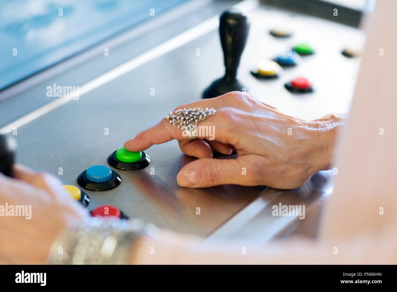 Close up di senior womans mano, premendo il pulsante sulla macchina di giochi Foto Stock