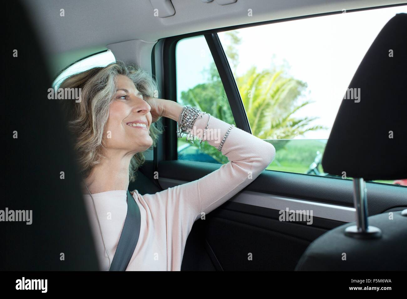 Senior imprenditrice guardando attraverso la finestra auto Foto Stock