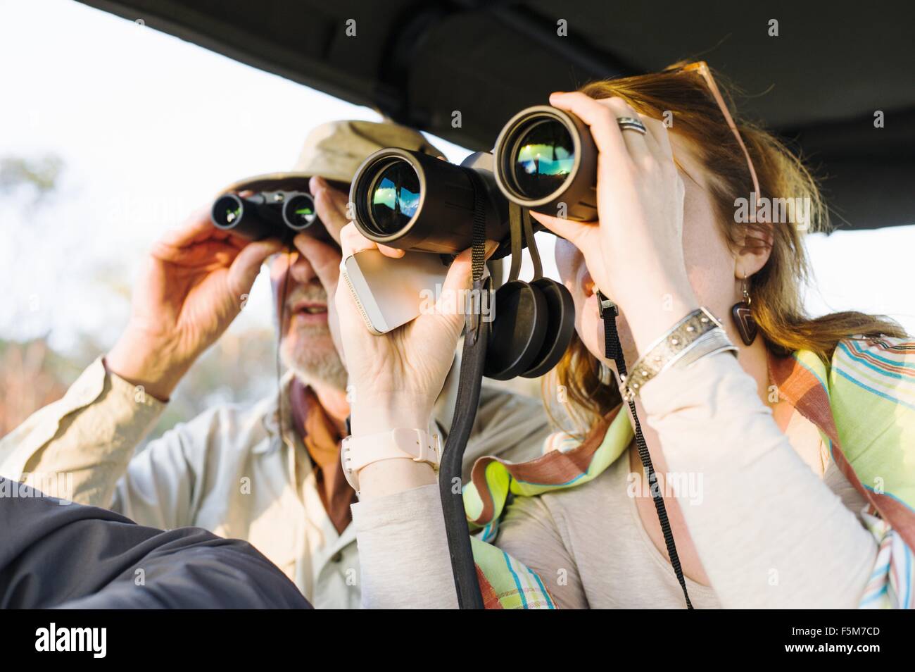 Uomo Senior e figlia guardando fuori attraverso il binocolo su Safari, Parco Nazionale di Kafue, Zambia Foto Stock
