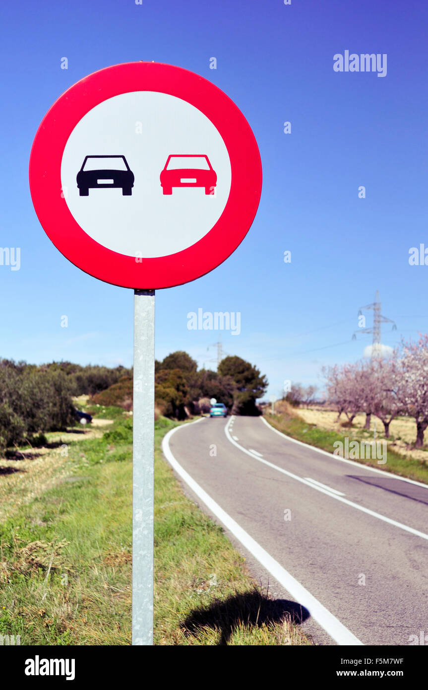 Nessun segno di sorpasso in una strada secondaria confina per olivi e mandorli in fiore Foto Stock