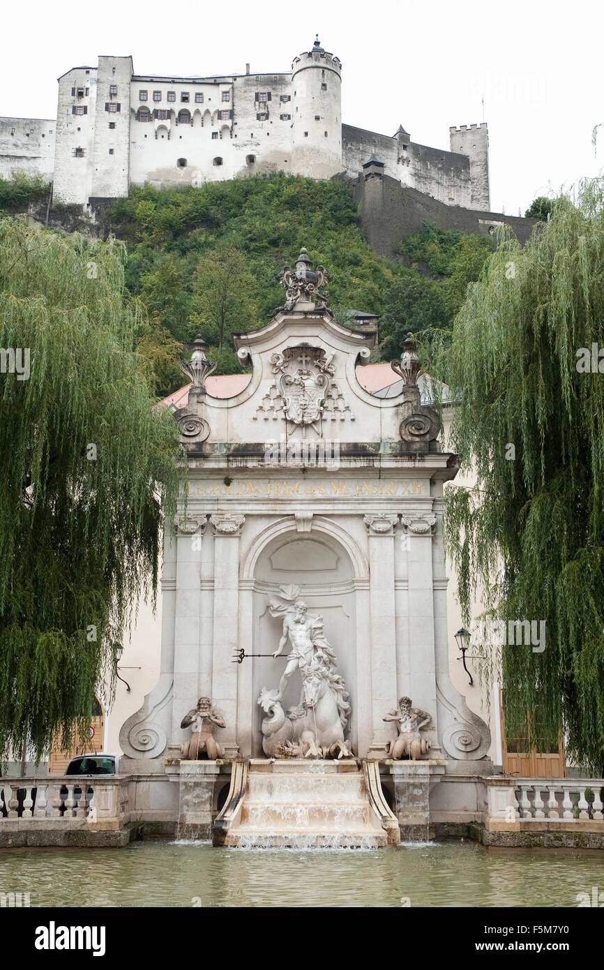 Basso angolo vista del castello di Hohensalzburg e la fontana di Nettuno, Salzberg, Austria Foto Stock