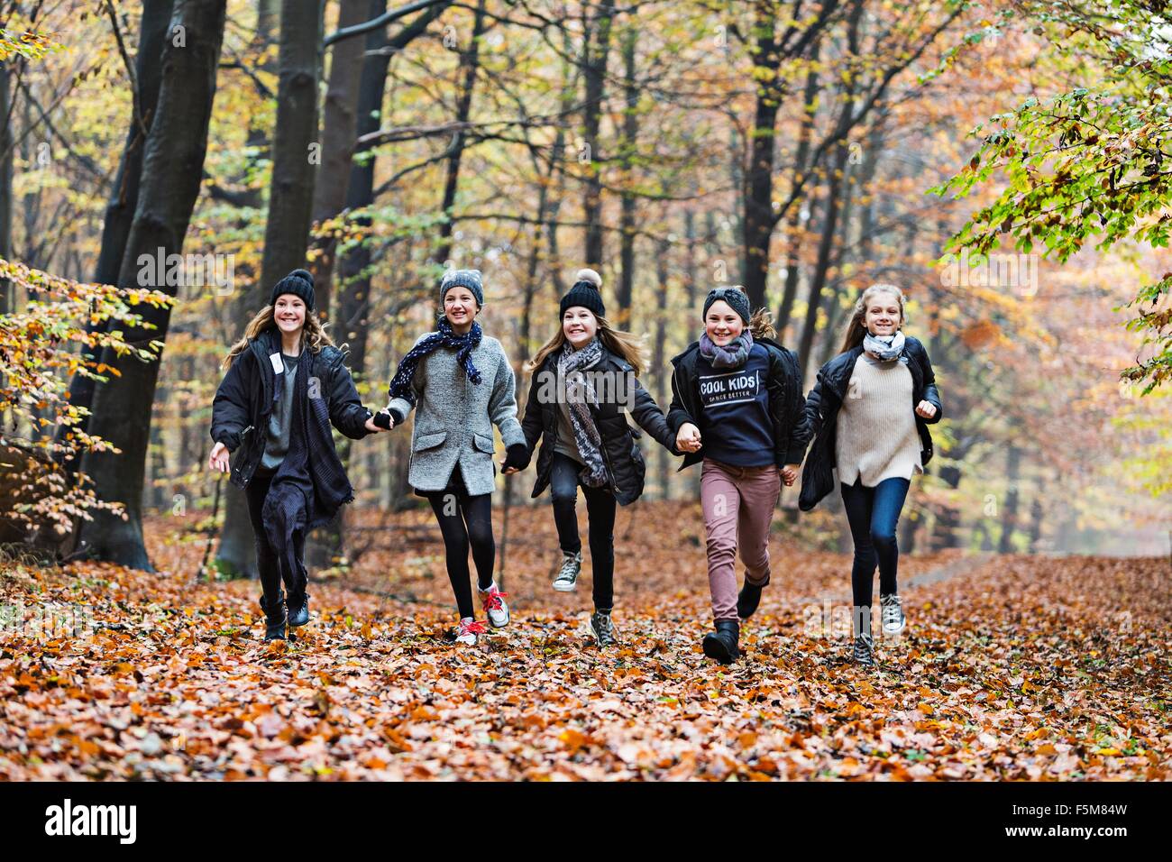 Le ragazze in esecuzione nella foresta di autunno Foto Stock