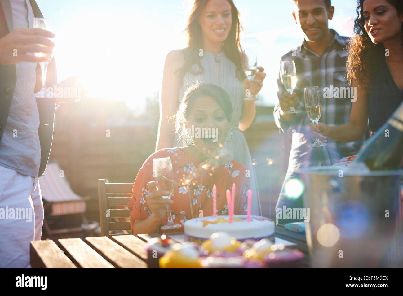 Amici di partito outdoor soffiando le candeline sulla torta Foto Stock