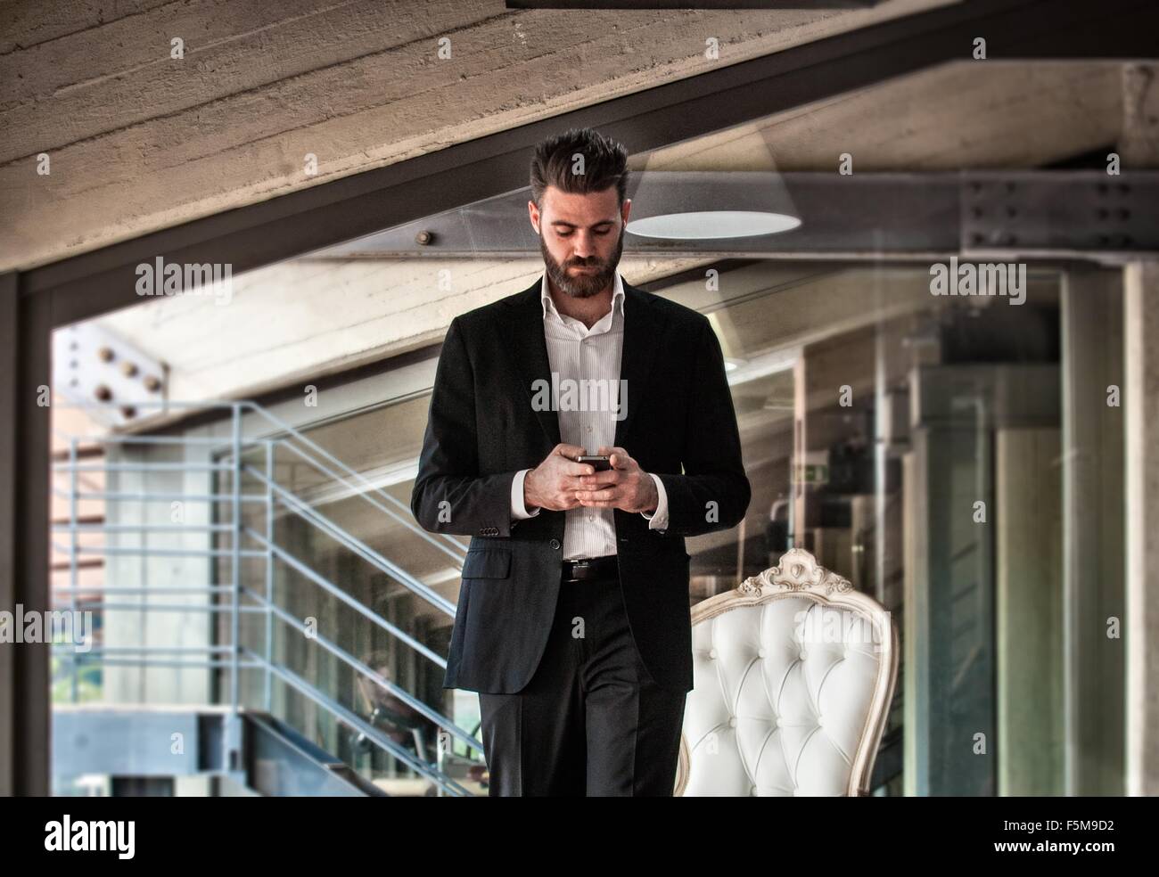 Metà uomo adulto indossare tuta smartphone holding guardando verso il basso Foto Stock