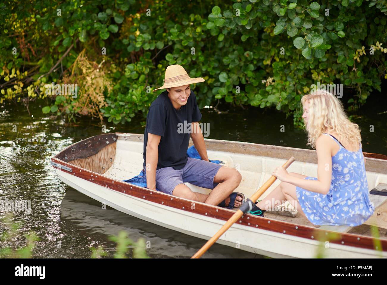 Coppia giovane canottaggio sul fiume in barca a remi Foto Stock