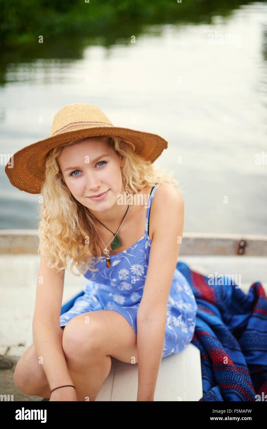 Ritratto di giovane donna con capelli lunghi biondi in barca sul fiume Foto Stock
