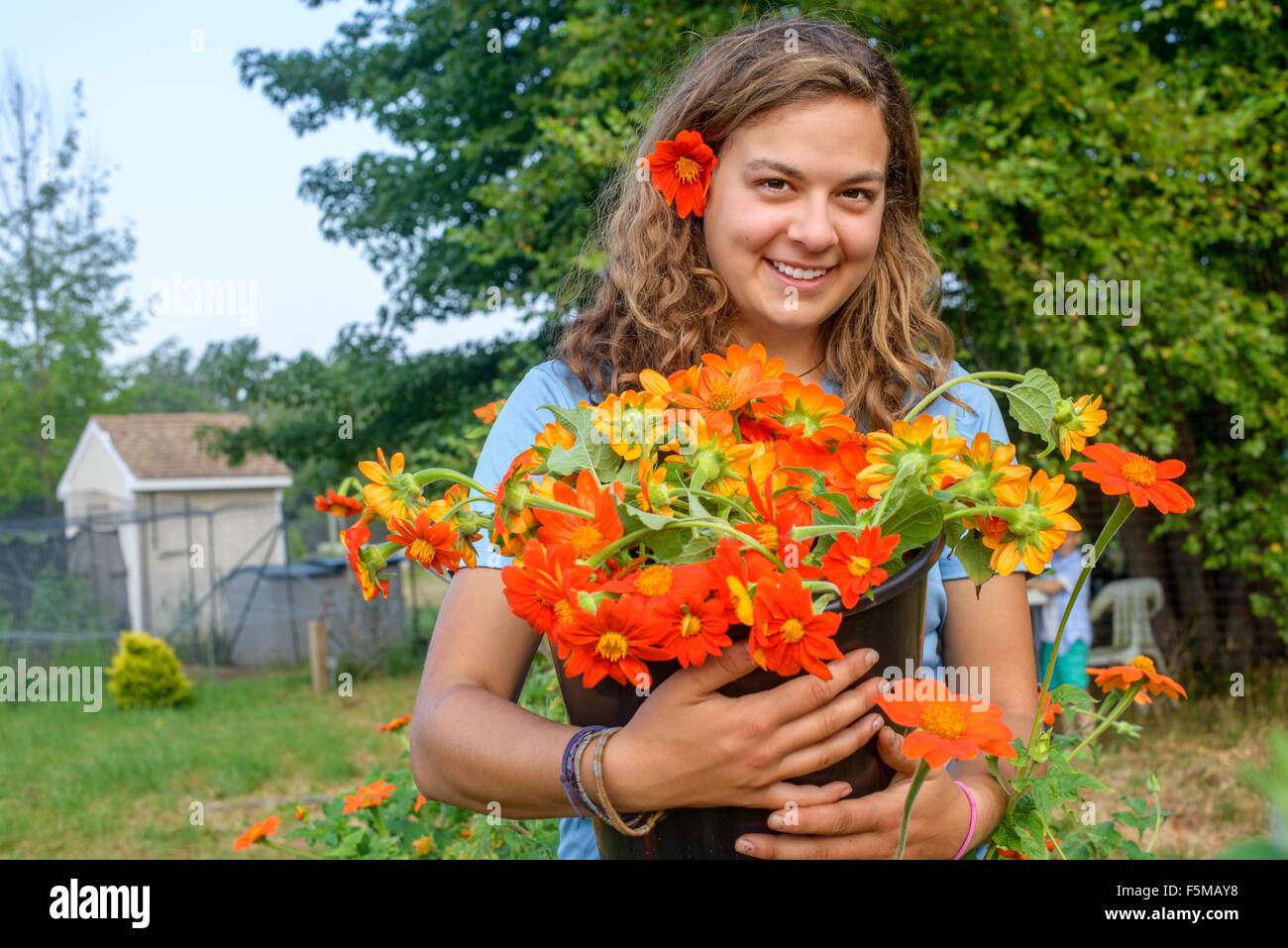 Ritratto di donna lavoratrice agricola tenendo un secchio di fiori recisi freschi Foto Stock