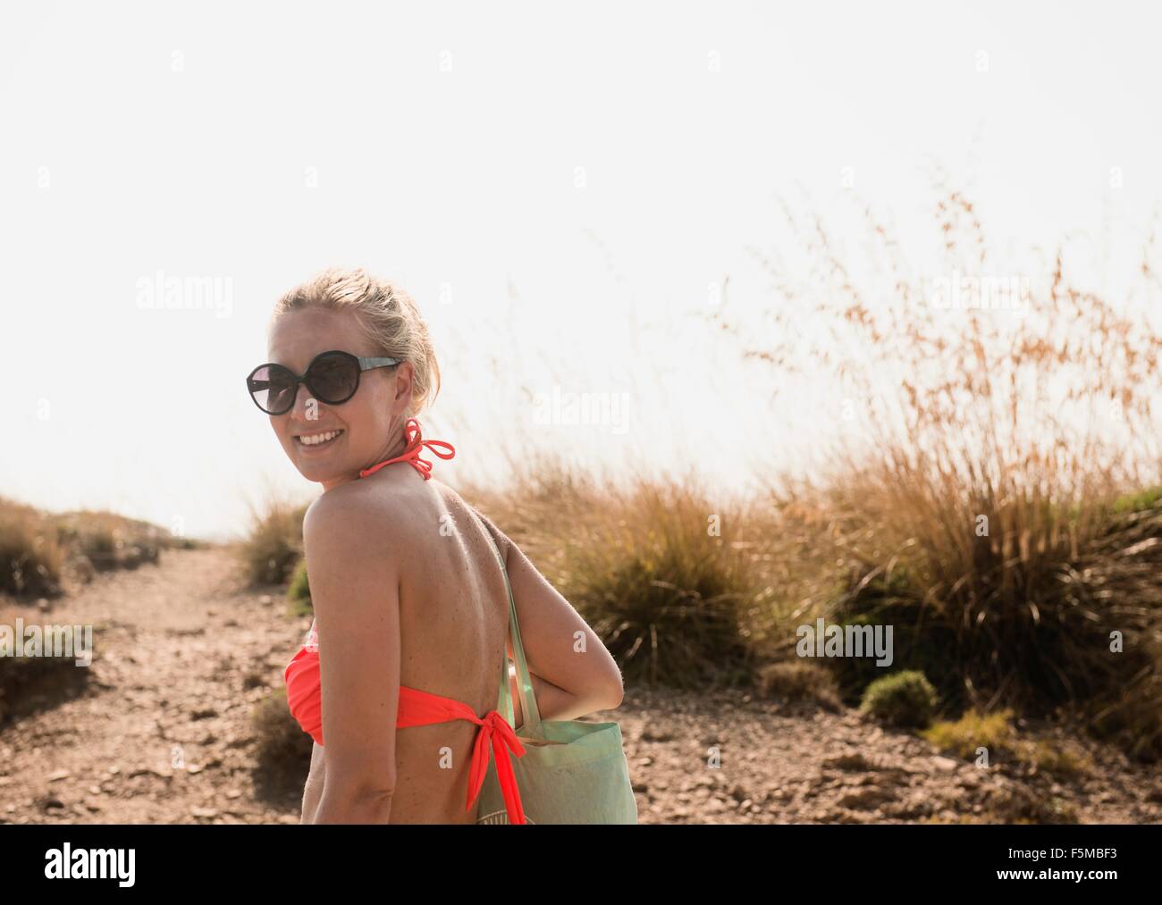 Ritratto di donna che indossa un bikini top in dune, Menorca, Spagna Foto Stock