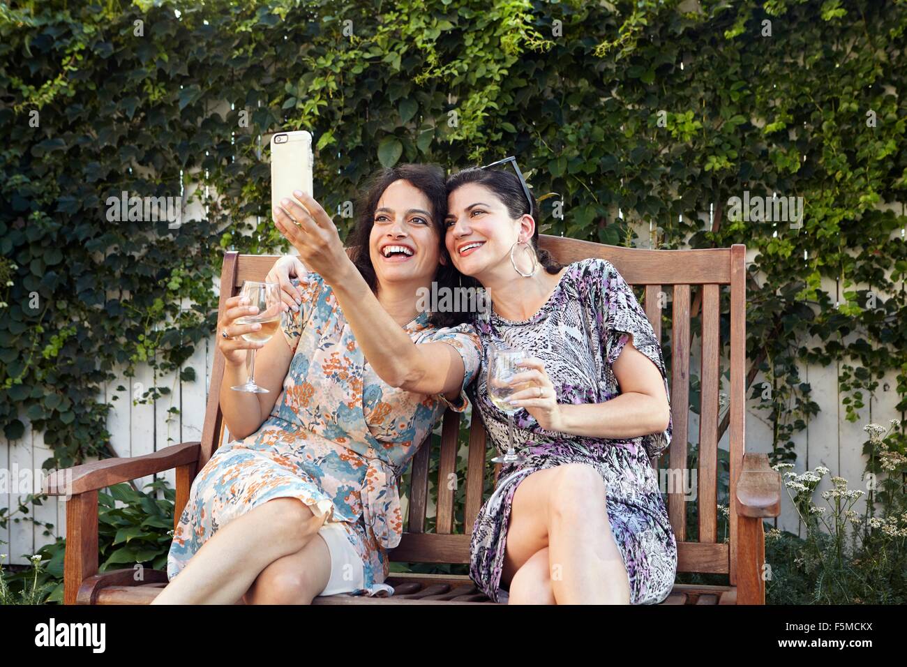 Due donne che prendono per smartphone selfie sul patio Foto Stock