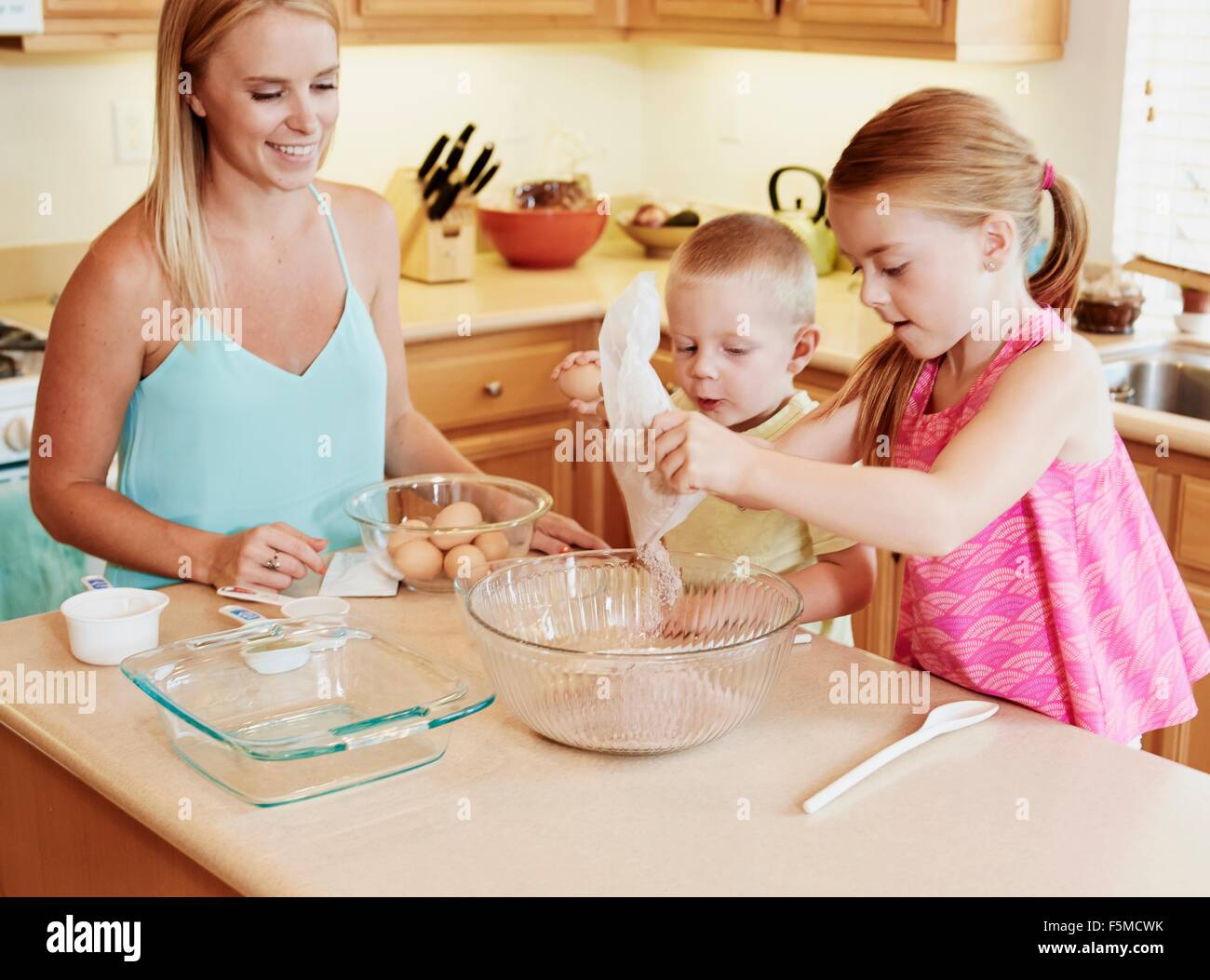 La famiglia la preparazione della pastella nel recipiente di miscelazione Foto Stock