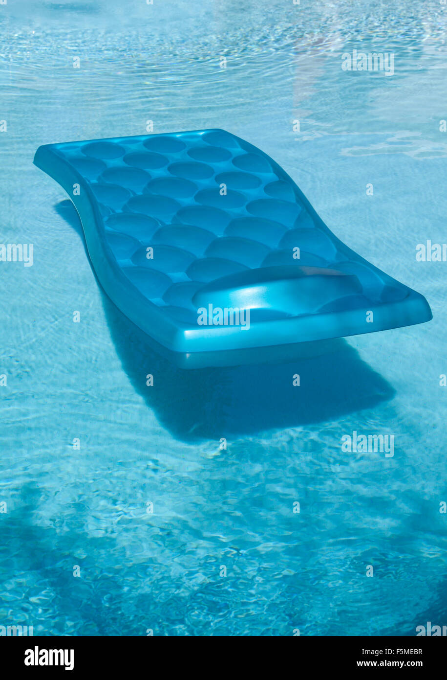 Lilo blu galleggiante sulla piscina Foto Stock