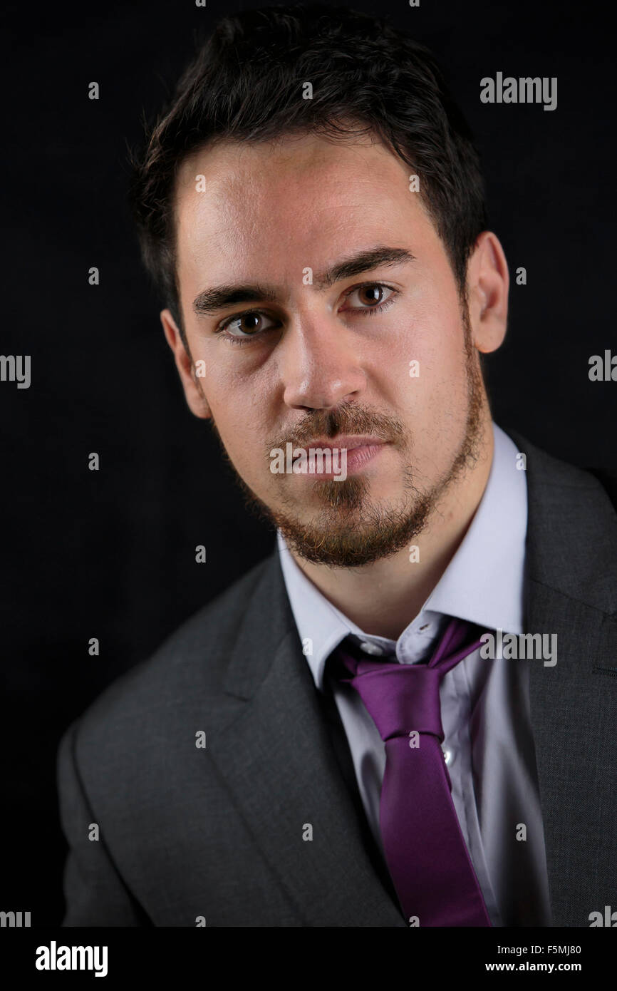 Smart business man in abito grigio con colletto aperto e cravatta viola. Foto Stock