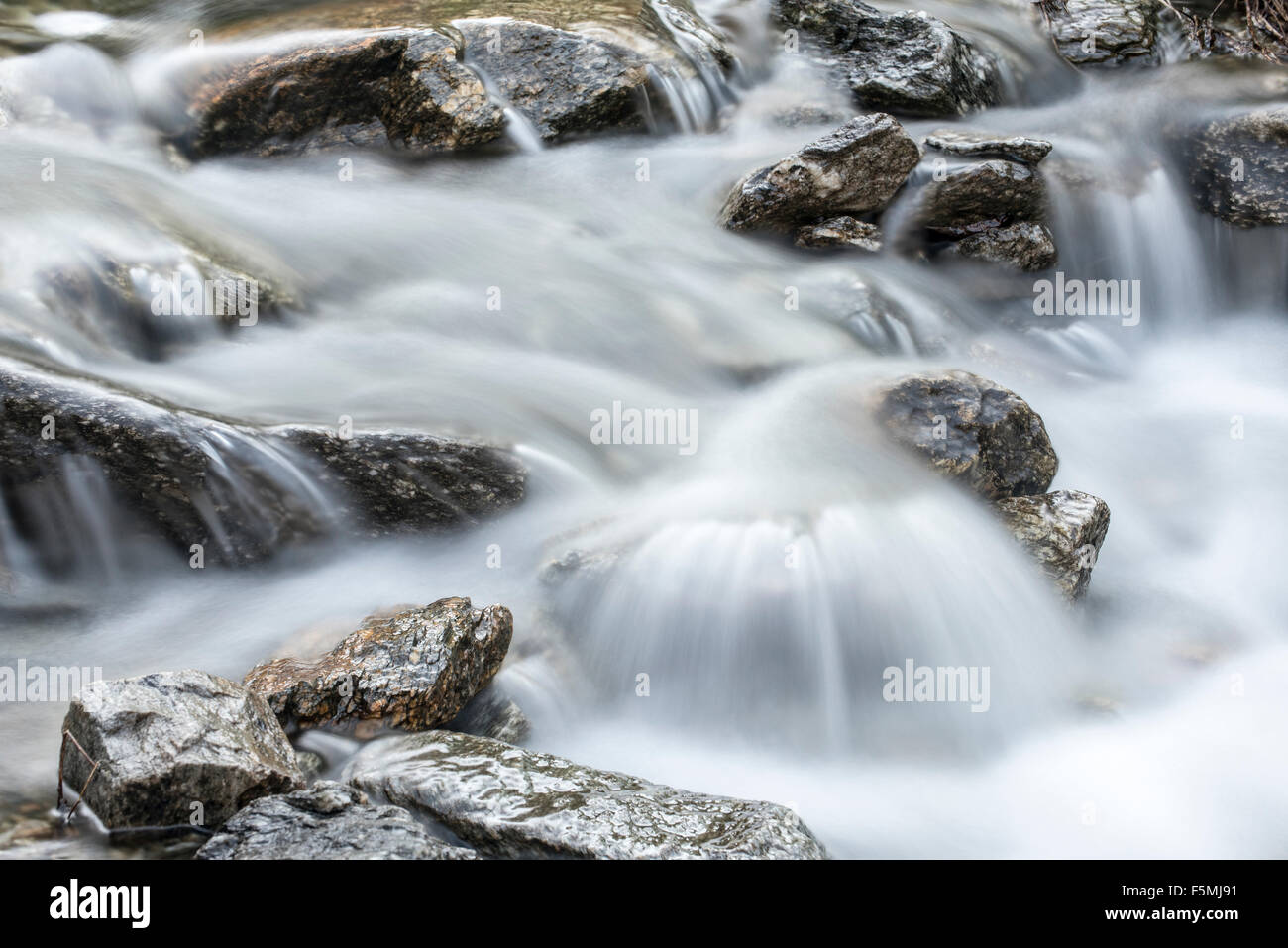 L'acqua che scorre sulle rocce nel ruscello di montagna Foto Stock