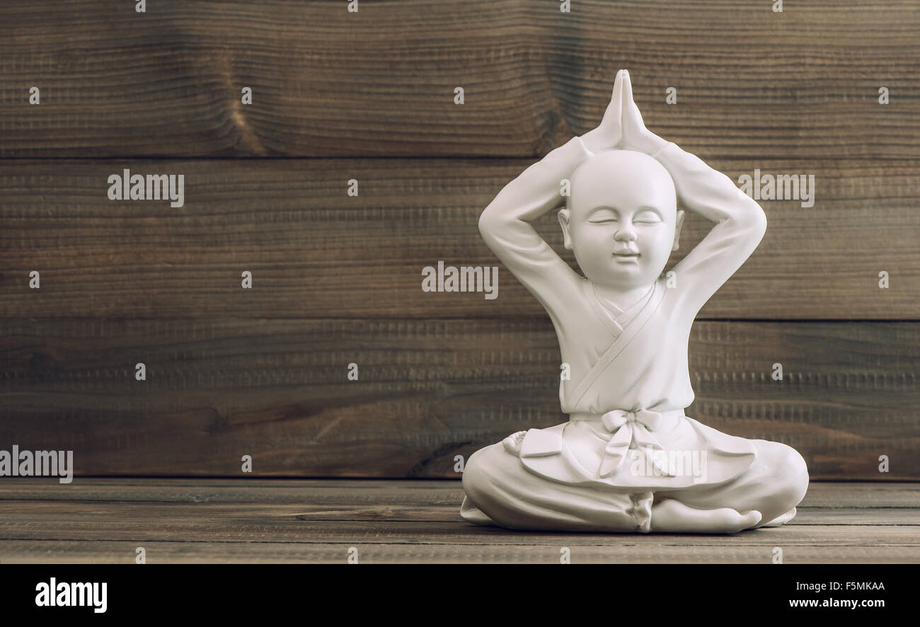 Il buddha bianco. Monaco scultura su sfondo di legno. La meditazione e relax Foto Stock