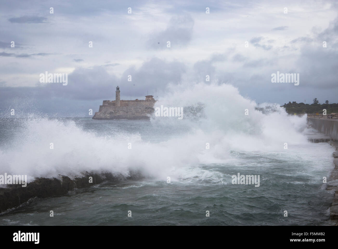Onde che si infrangono vicino al Malecon con Morro Castle in background, Havana, Cuba Foto Stock
