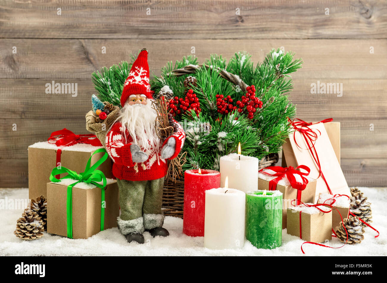 Decorazione di Natale con Babbo Natale, candele accese e confezioni regalo. In stile vintage nei toni dell'immagine. Nessun nome toy prodotte in massa Foto Stock