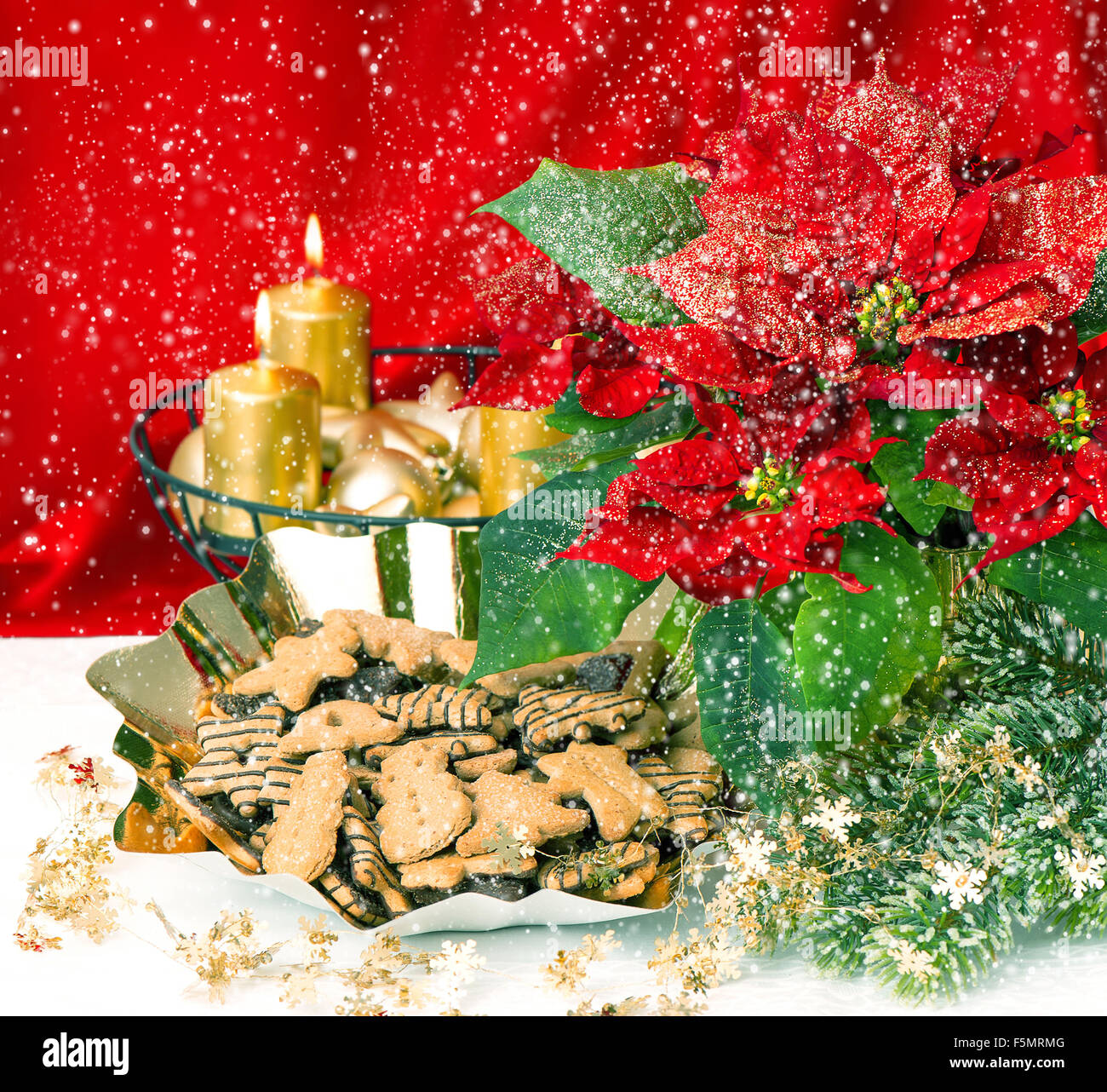 Avvento decorazione con la masterizzazione di golden candele, poinsettia flower e Natale gingerbread cookie. In stile vintage tonica foto Foto Stock