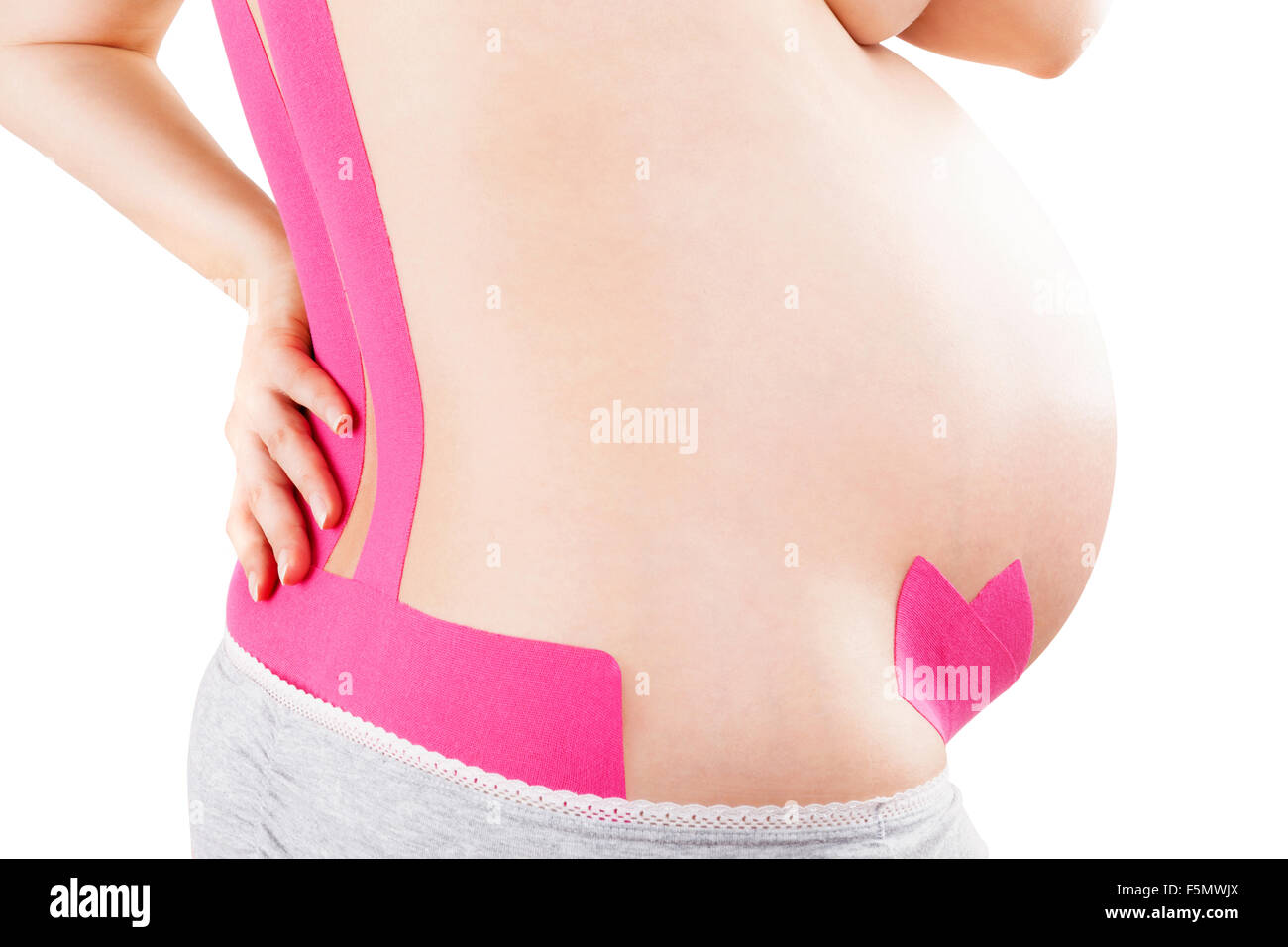 Bella donna incinta con kinesio nastro sul suo retro. Mal di schiena in gravidanza, alternativa nastro kinesio terapia. Foto Stock