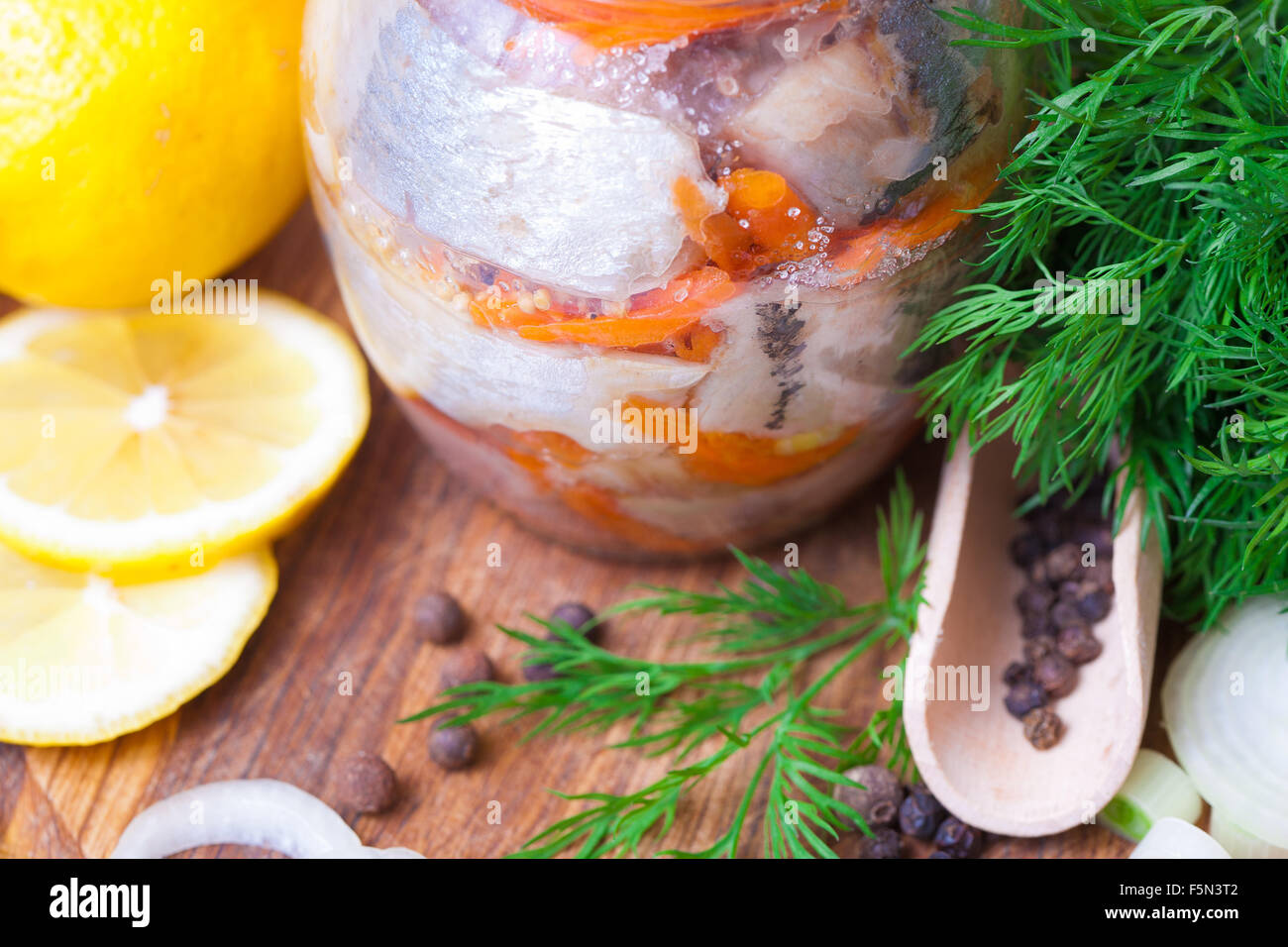 Le aringhe marinate in un vaso con le verdure e le erbe aromatiche Foto Stock