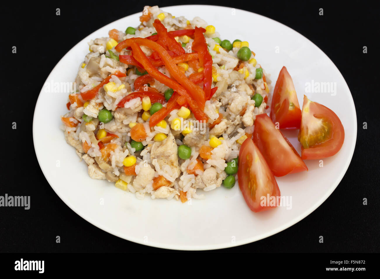 Risotto di pollo su una piastra di sfondo scuro Foto Stock