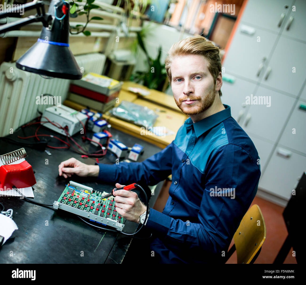 Giovane uomo che lavora nel laboratorio di elettronica Foto Stock