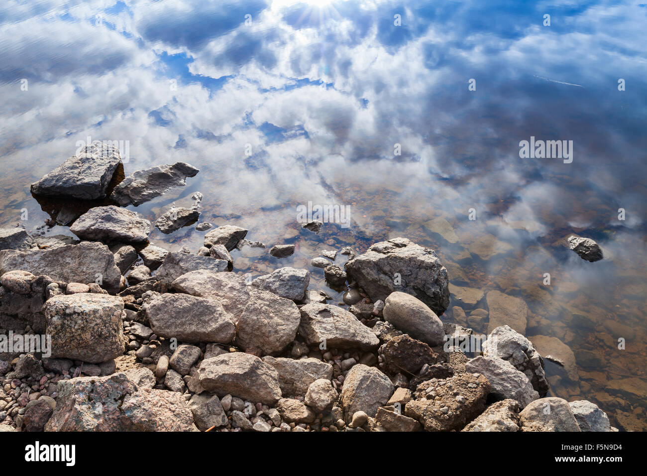 Ancora il lago di costa, costiere e pietre blu cielo nuvoloso riflesso nell'acqua Foto Stock