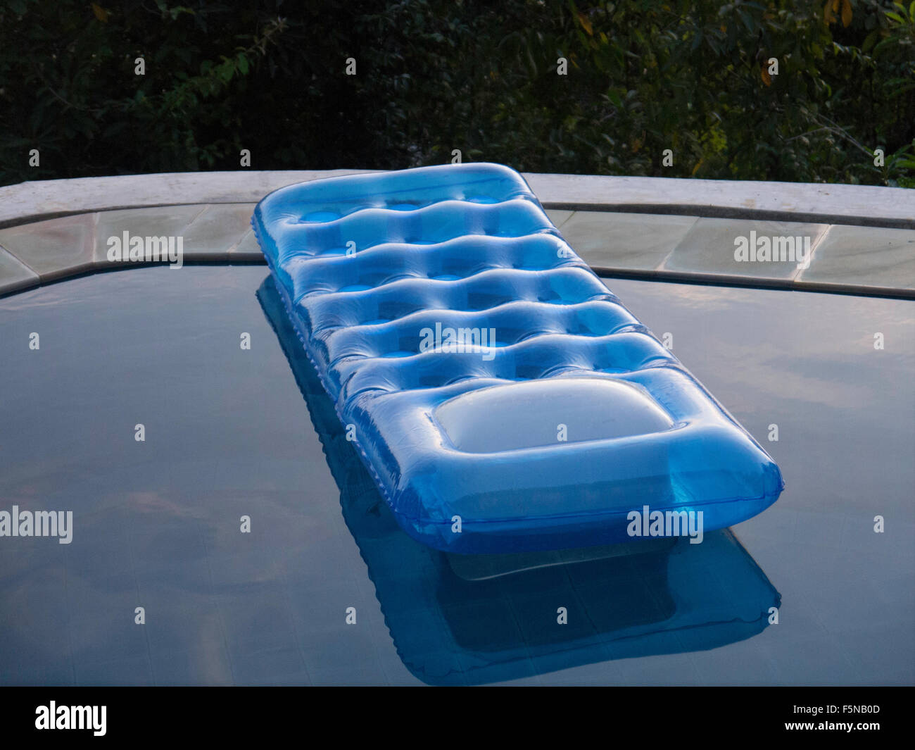 Blue lilo galleggianti sulla superficie della piscina Foto Stock