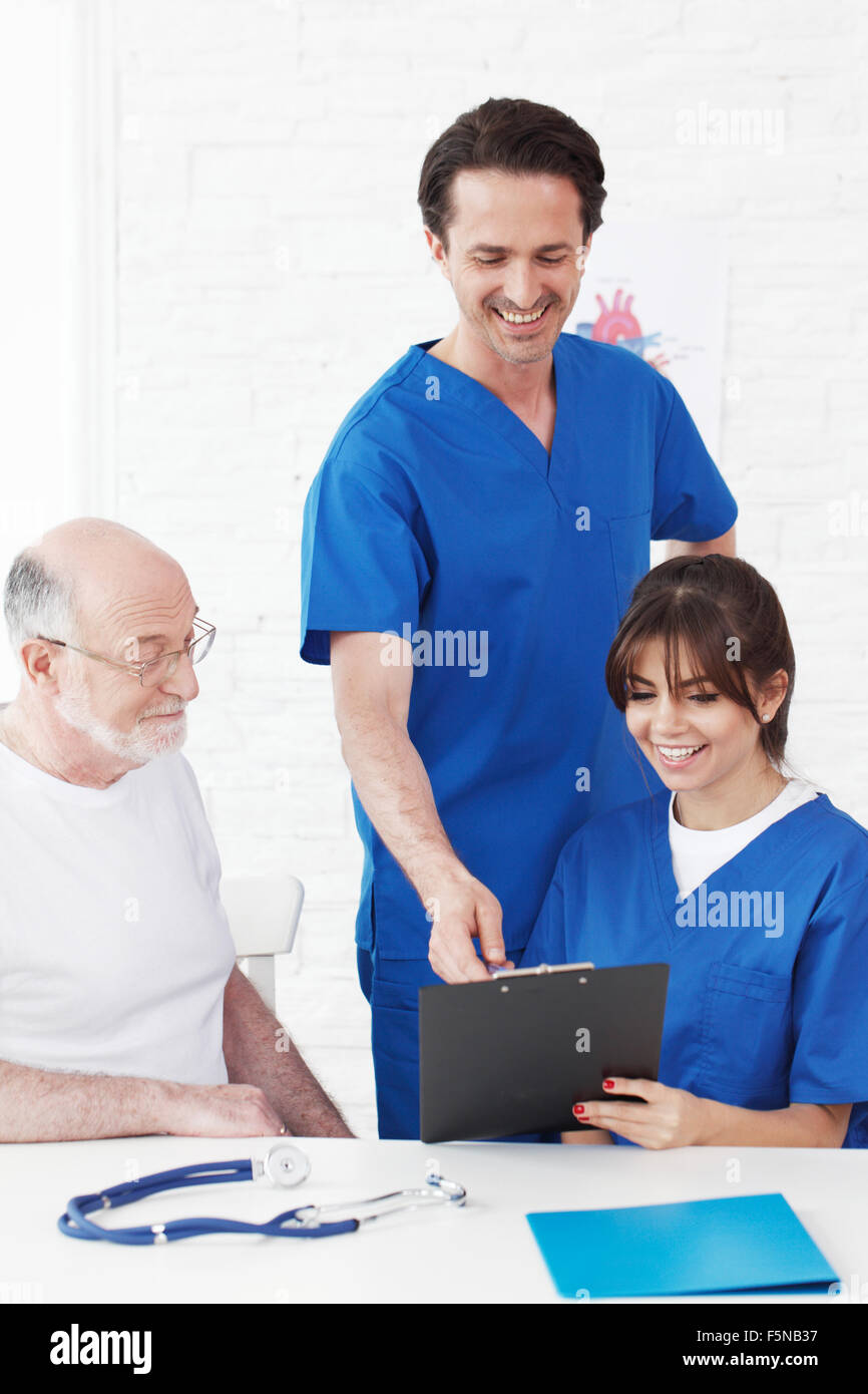 Felice paziente senior e i medici in ospedale Foto Stock