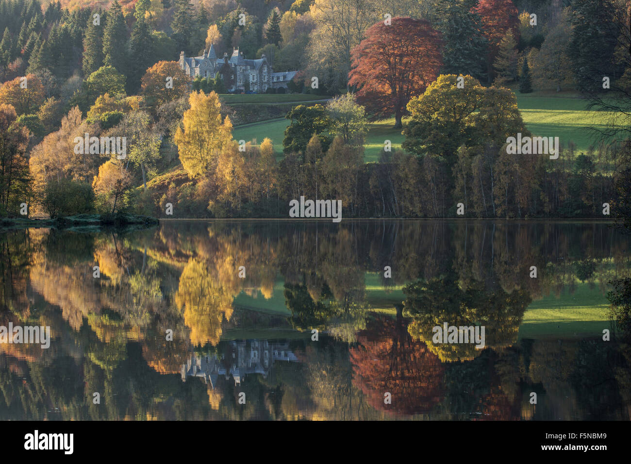 Riflessioni perfetta dei colori autunnali a Loch Tummel, Scozia Foto Stock