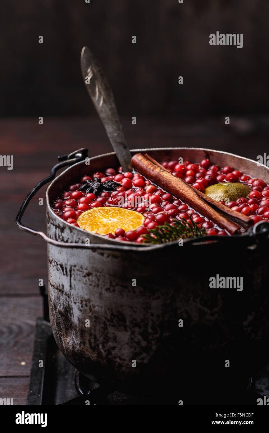 Mirtillo rosso melograno mandarino punch o vin brulé in un rustico invecchiato pot Foto Stock