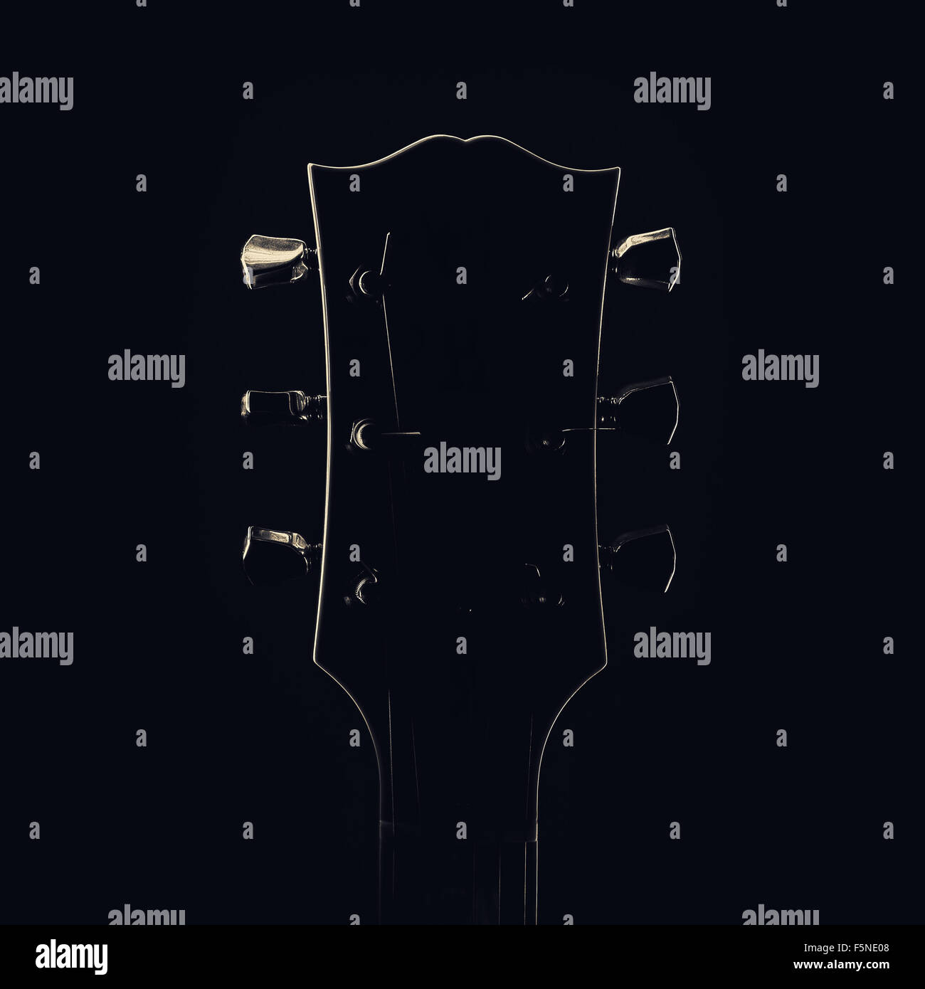 La testa e il collo della chitarra elettrica, forme accentuata dalla luce. Foto Stock