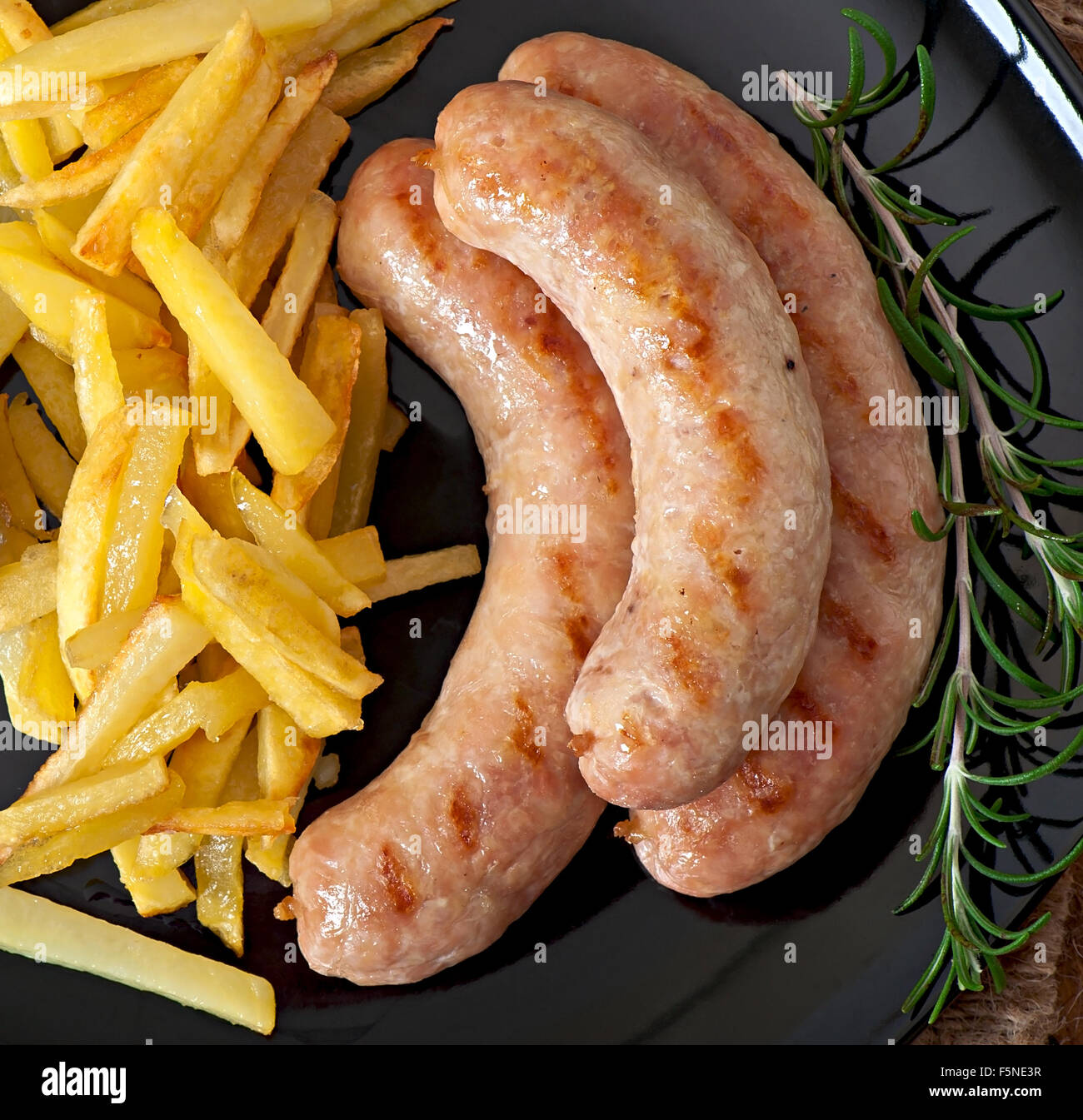 Salsicce di pollo alla griglia con contorno di patate fritte Foto Stock