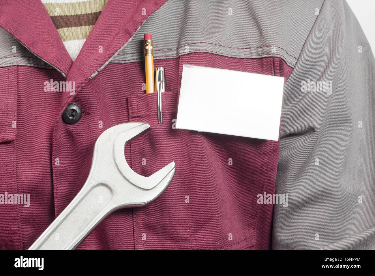 Close-up di nome vuoto sul tag di servizio l'uomo uniforme e una grossa chiave inglese Foto Stock