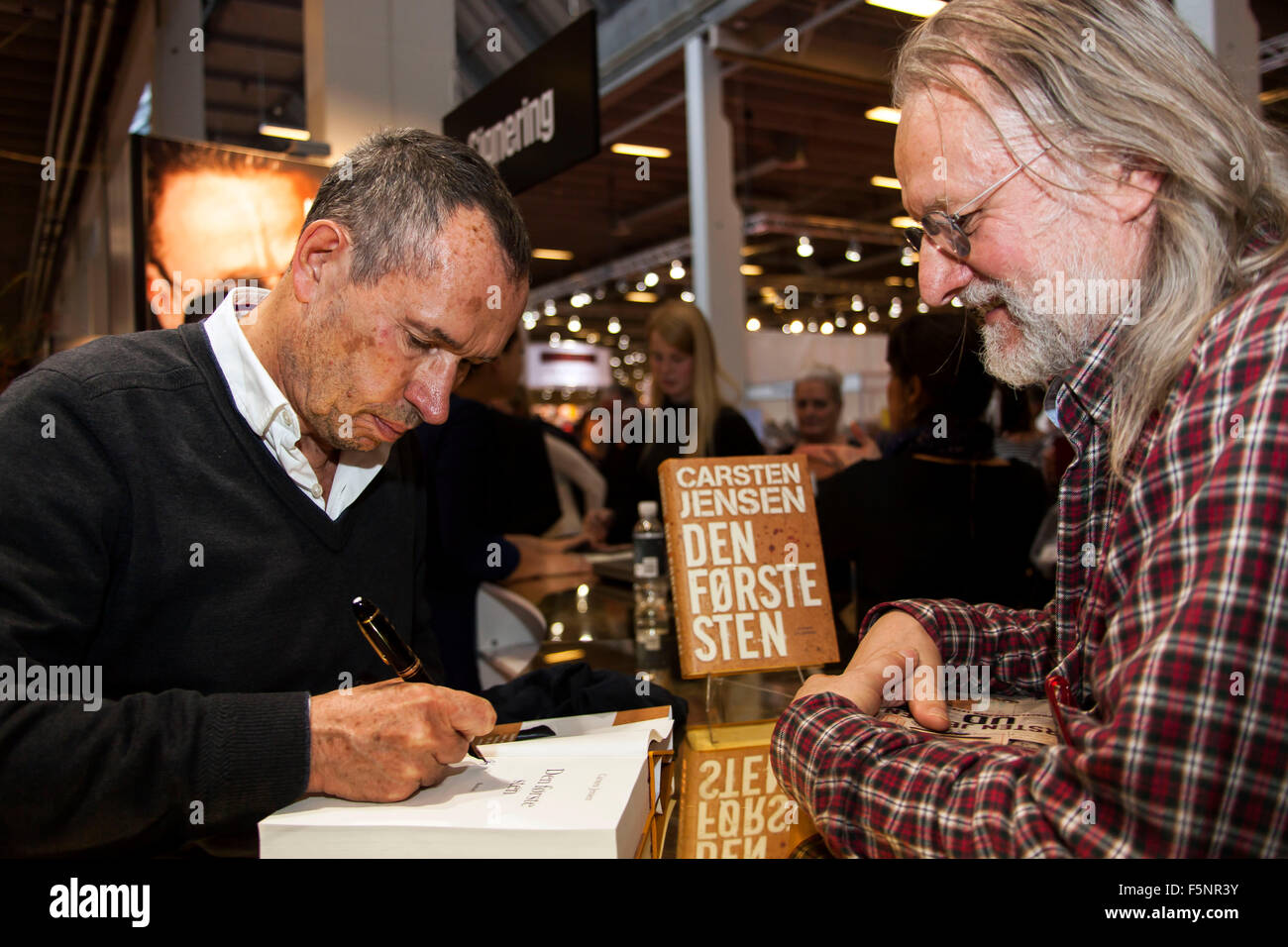 Copenhagen, Danimarca, Novembre 7th, 2015. Autore danese Carsten Jensen (L) i segni del suo nuovo libro "Den Første Sten" (leggere: la prima pietra") circa la guerra e i soldati danesi in Afghanistan. a Copenaghen Salone circa il suo nuovo libro, Credito: OJPHOTOS/Alamy Live News Foto Stock