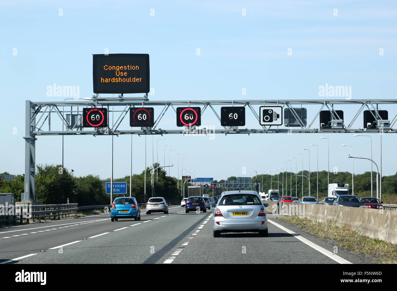 Il traffico sulla autostrada m5.. Un overhead gantry mostra gli avvisi di congestione in anticipo e limite di velocità di 60km/h. le telecamere di velocità sono posizionati sul gantry Foto Stock