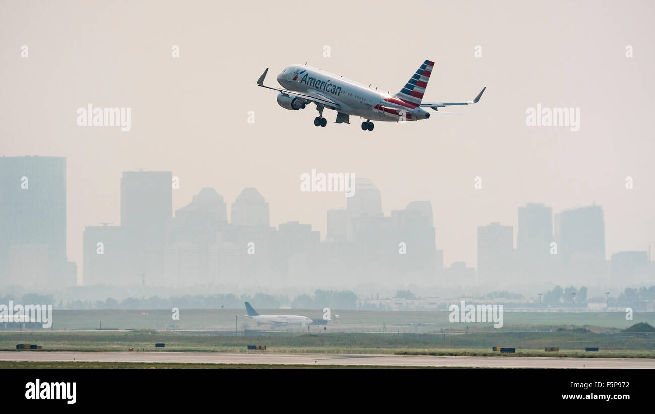American Airlines Airbus A319 decolla da Calgary, Alberta in molto fumoso smoky condizioni causate da incendi boschivi Foto Stock