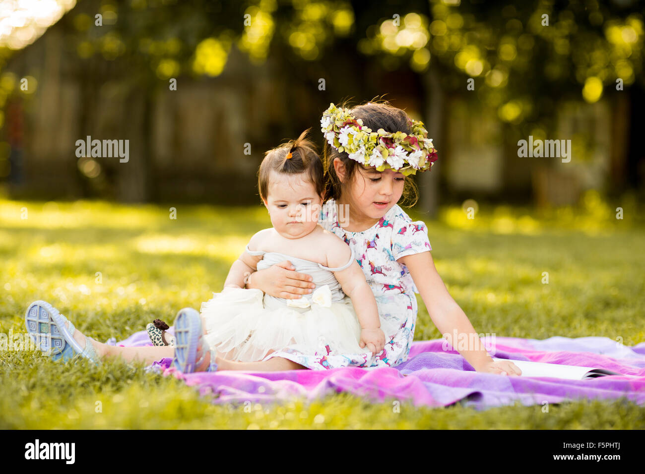 Bambina e baby sitting in erba Foto Stock