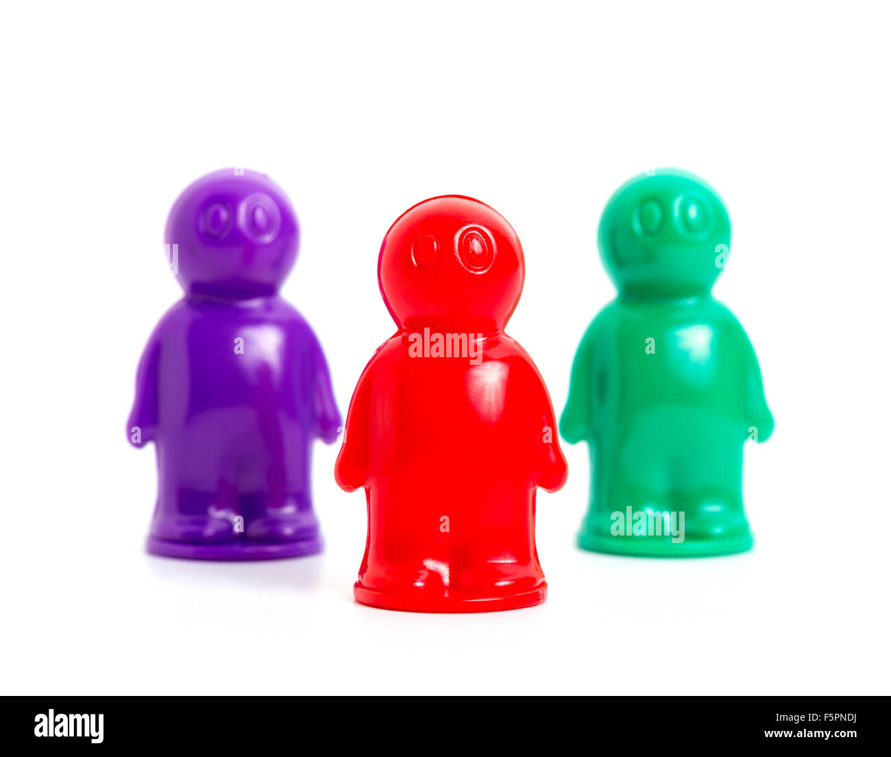 Tre piccoli toy businessmans di diversi colori Foto Stock
