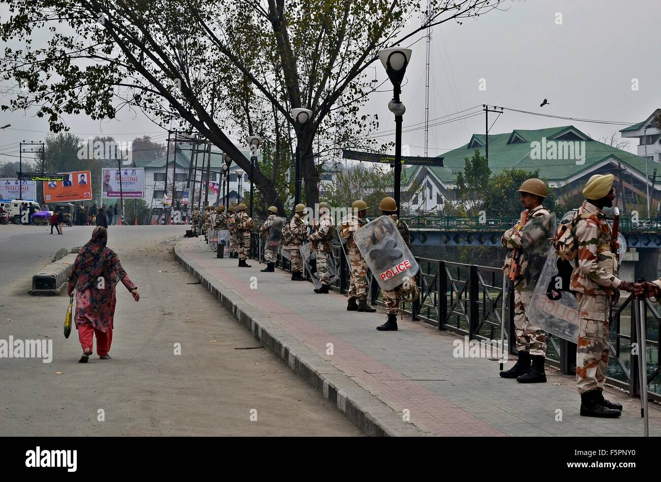 Una donna del Kashmir passeggiate passato le forze paramilitari in Srinagar Dalgate dell'area. Autorità restrizione imposti in molte parti di Srinagar avanti davanti al Primo Ministro indiano Narendra Modi di visitare il sito web Foto Stock