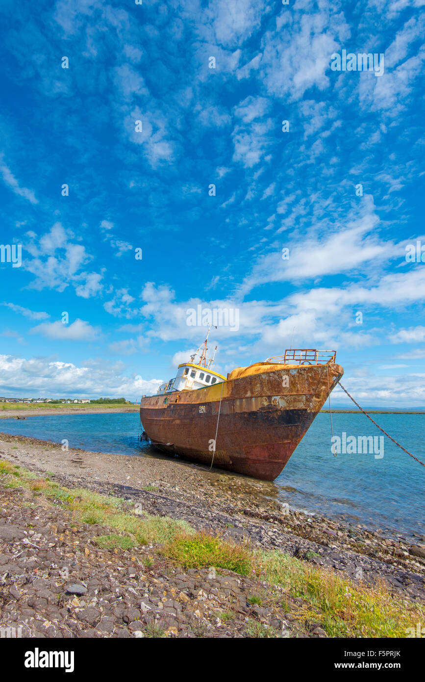 Una lavata fino abbandonato rusty barca ad alta marea su una giornata d'estate Foto Stock