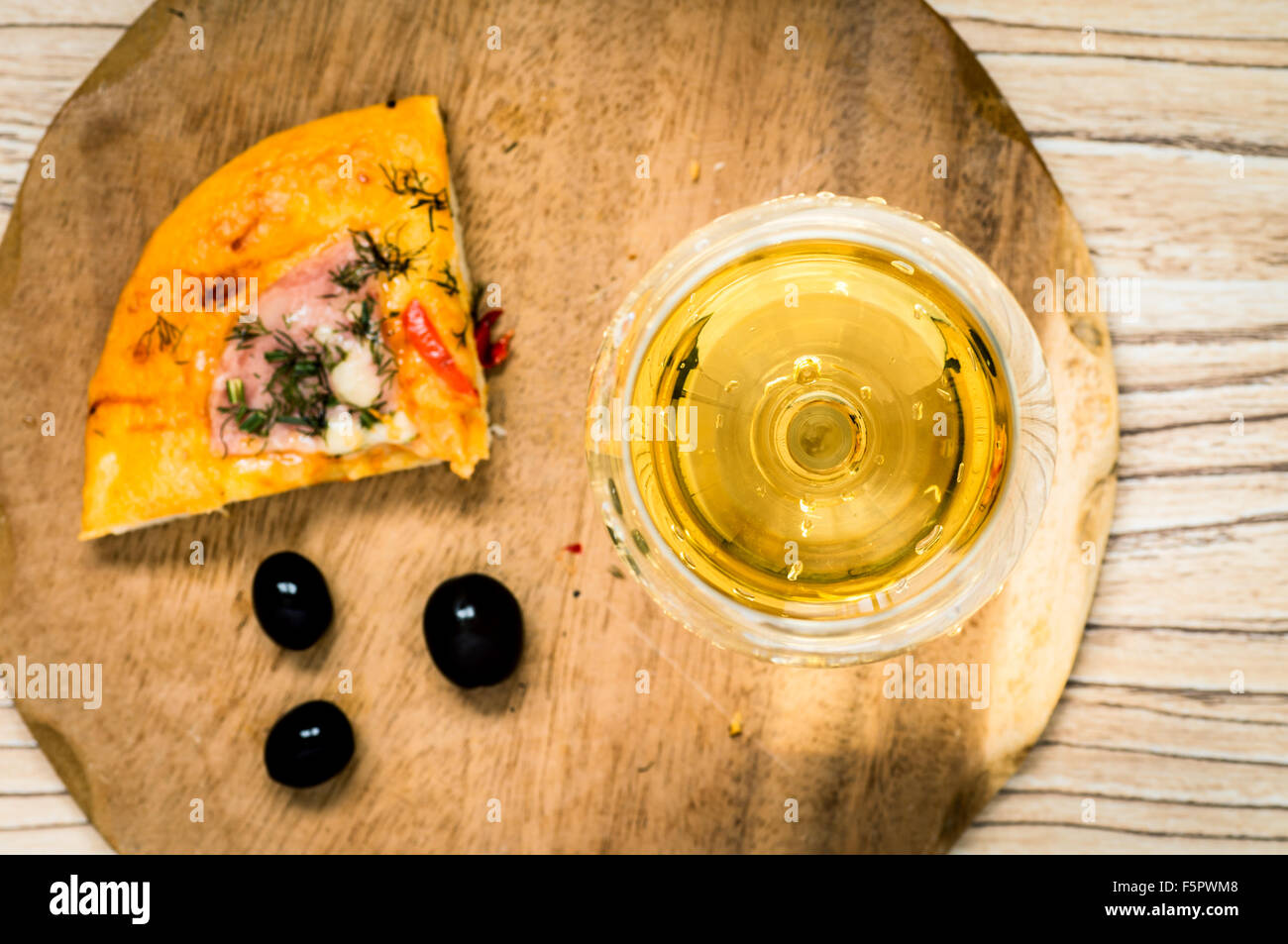 Bicchiere di vino bianco e un trancio di pizza e olive vista superiore Foto Stock