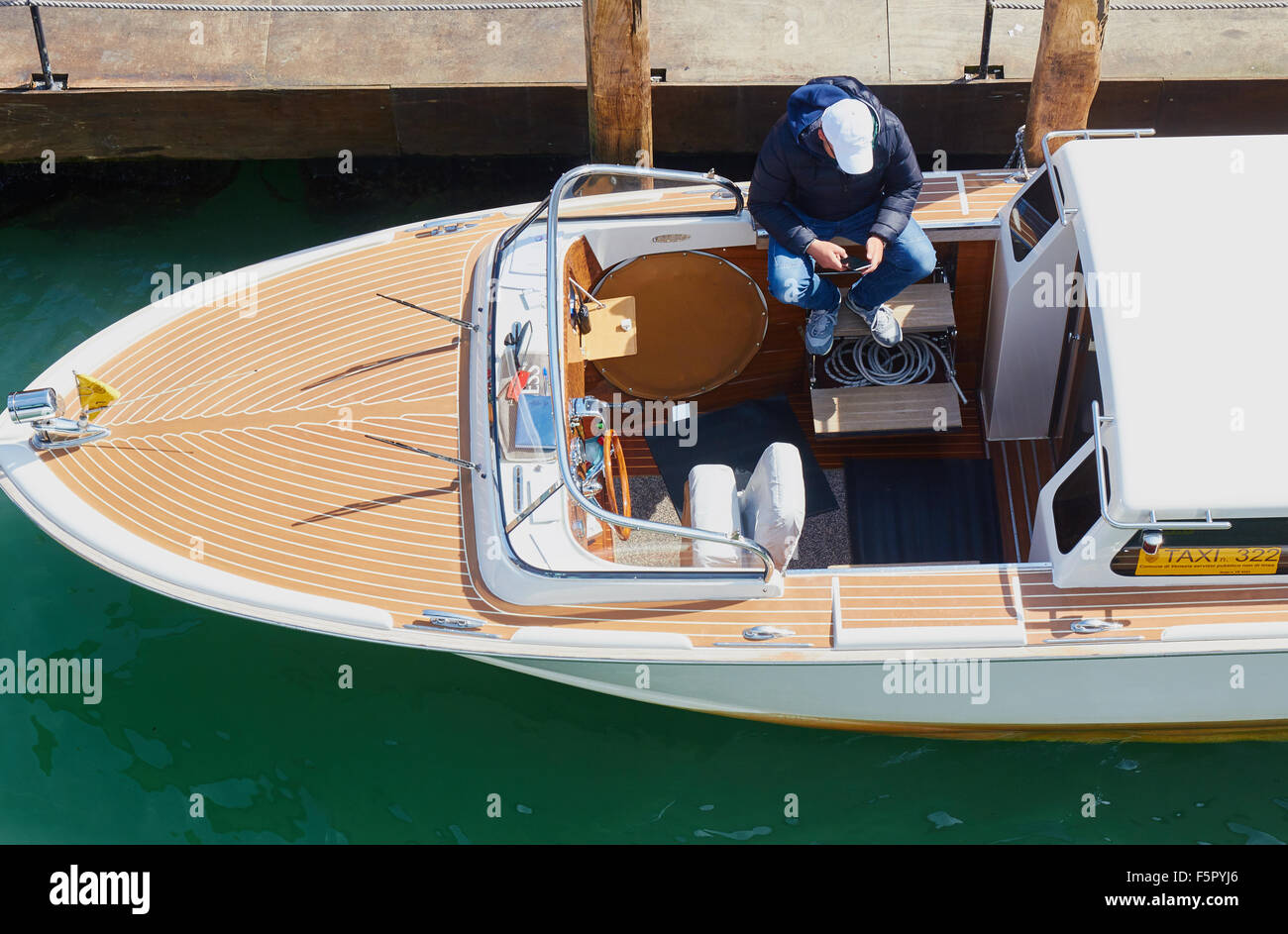Acqua motoscafi taxi conducente seduto nella sua barca Venezia Veneto Italia Europa Foto Stock