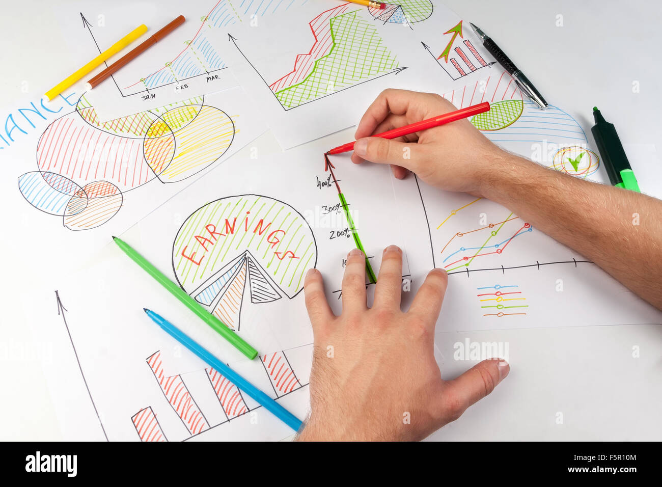 L'uomo pittura diagrammi di business su white paper con soft-tip pen Foto Stock