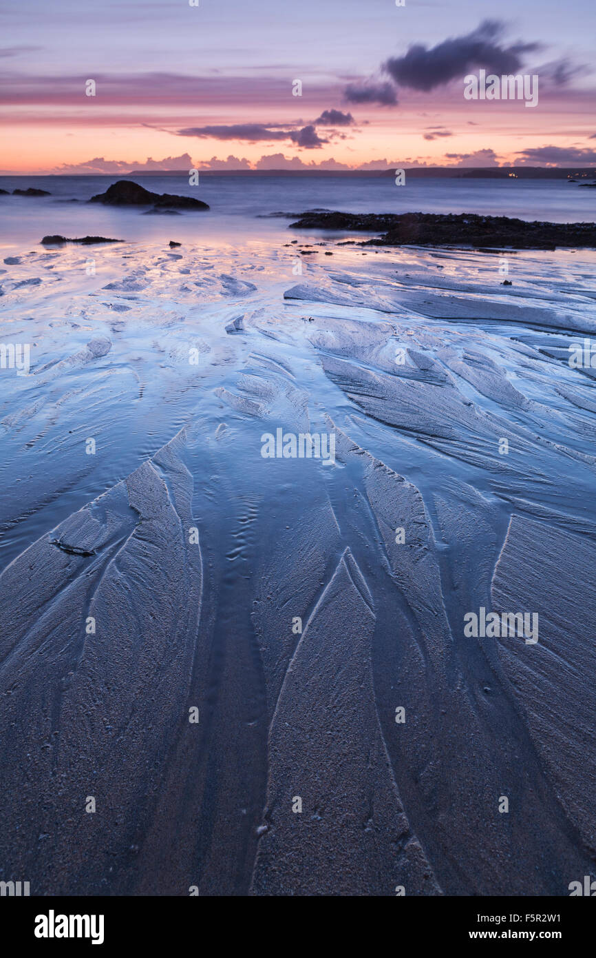 Modelli di sabbia sulla spiaggia Mouthwell creata dalla marea sfuggente al tramonto, Speranza Cove, Devon. Foto Stock