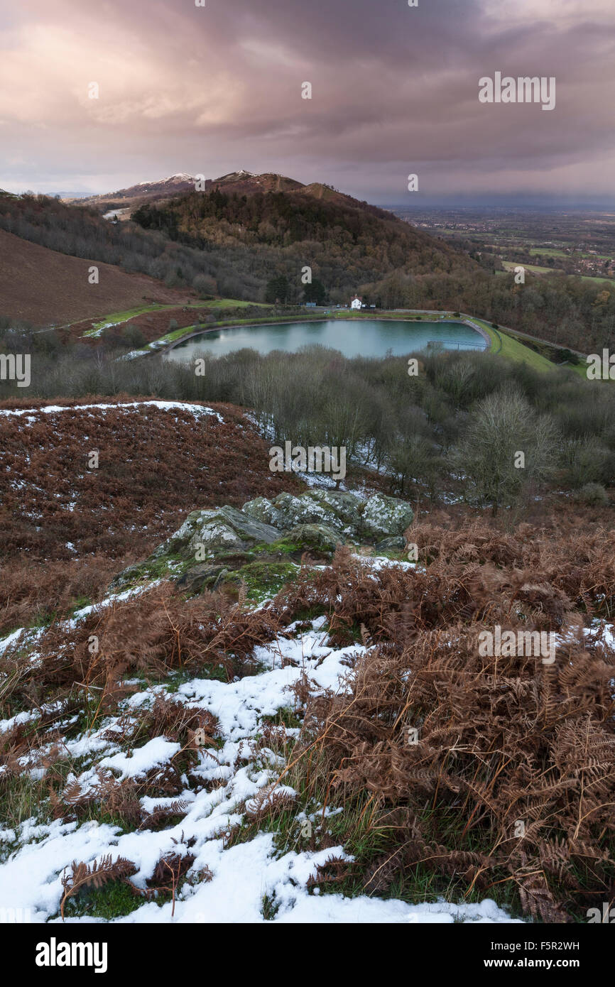 Il serbatoio a British Camp, parte della Malvern Hills in Herefordshire e Worcestershire al tramonto con macchie di neve. Foto Stock