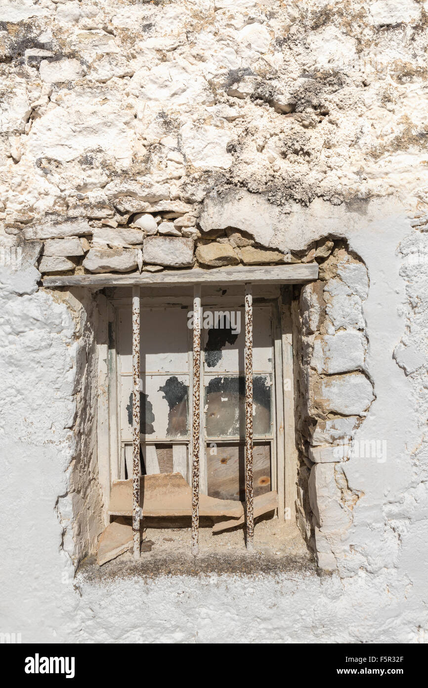 Una finestra sbarrata in un edificio in pietra. Foto Stock