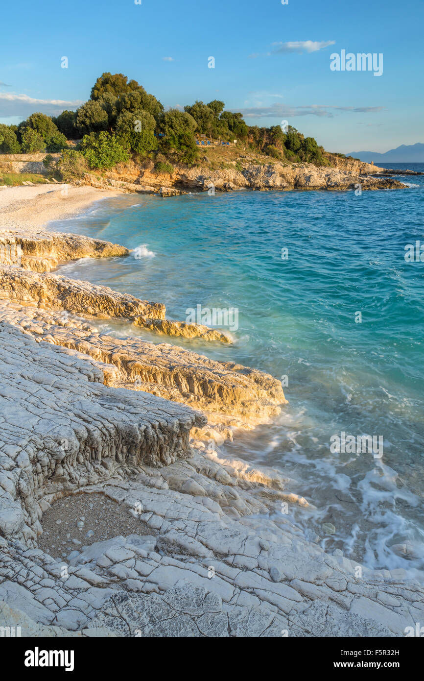 Le rocce sulla spiaggia Bataria, Kassiopi Corfù sono accesi con la forte luce arancione di sunrise. Foto Stock