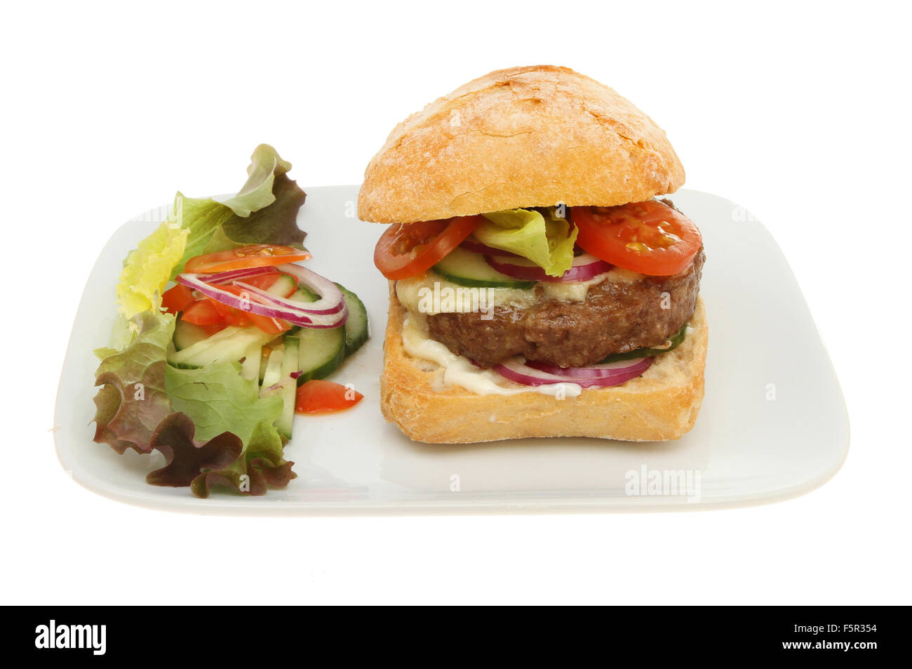 Cheesburger in un rotolo di pasta acida con insalata e guarnire su una piastra isolata contro bianco Foto Stock